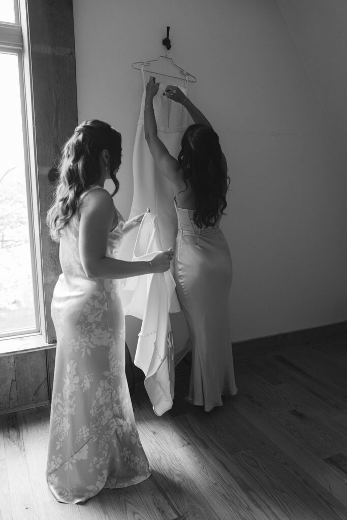 Bridesmaids helping bride with her gown, preparing for the City Winery wedding ceremony.