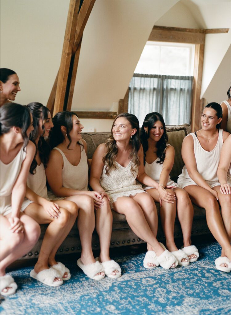Bride and bridesmaids in matching loungewear and slippers, smiling before City Winery wedding.