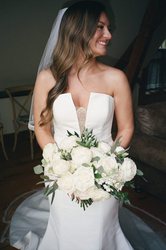 Bride smiling with bouquet of white roses and peonies before City Winery wedding.