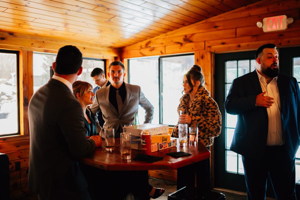 Guests gather around a tall table with drinks and board games at The Arnold House.