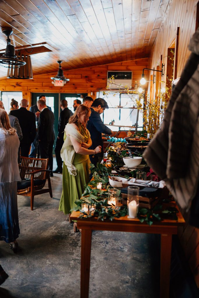Guests line up at a buffet decorated with candles and greenery at The Arnold House.