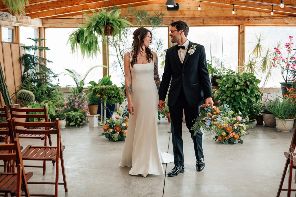 wedding portrait of bride and groom surrounded by greenery and florals at The Arnold House