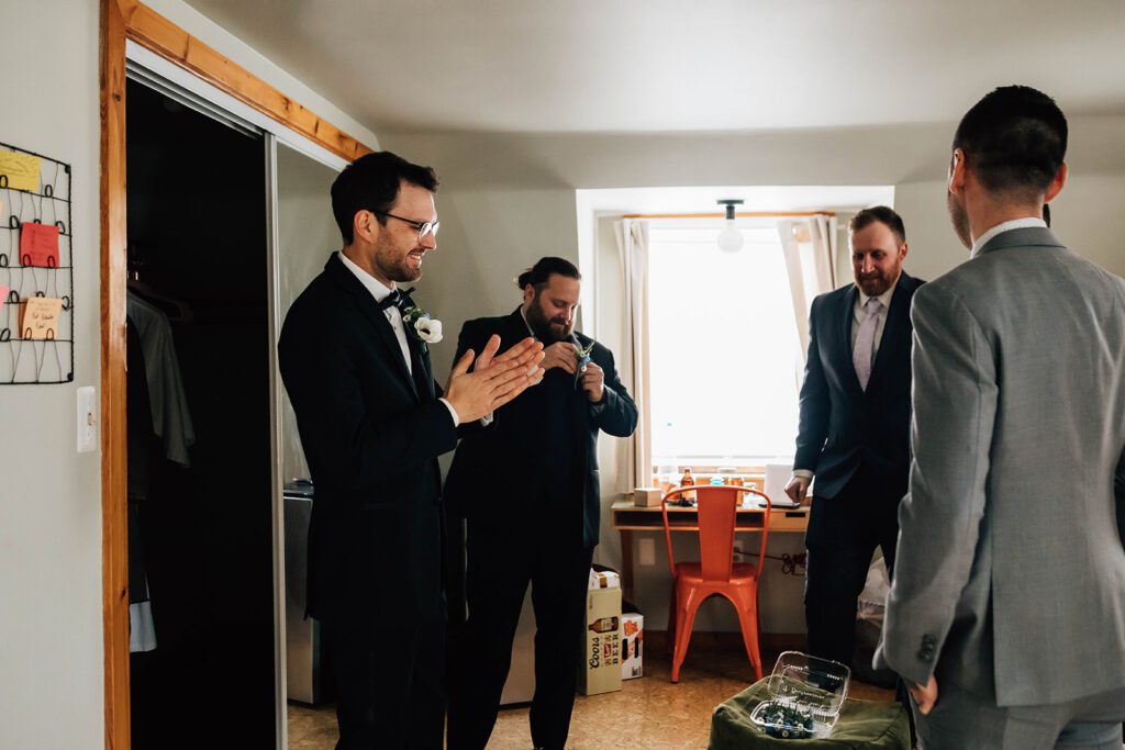 Groom and groomsmen share a laugh while getting ready inside The Arnold House.