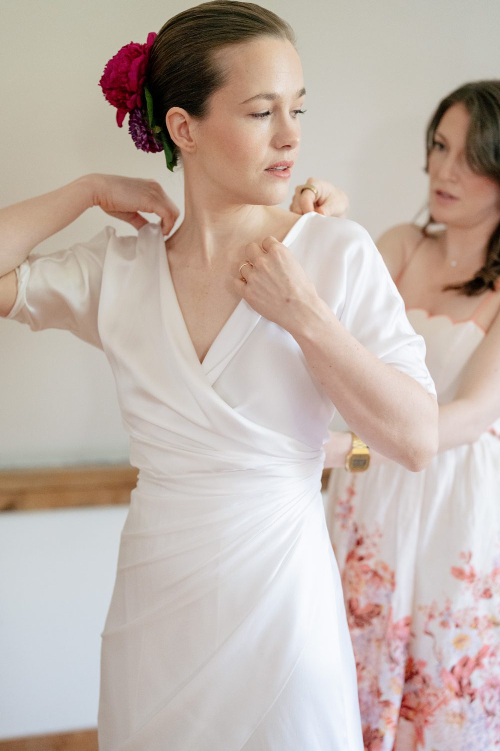 BRIDEMAID HELPS BRIDE ADJUST HER WEDDING DRESS
