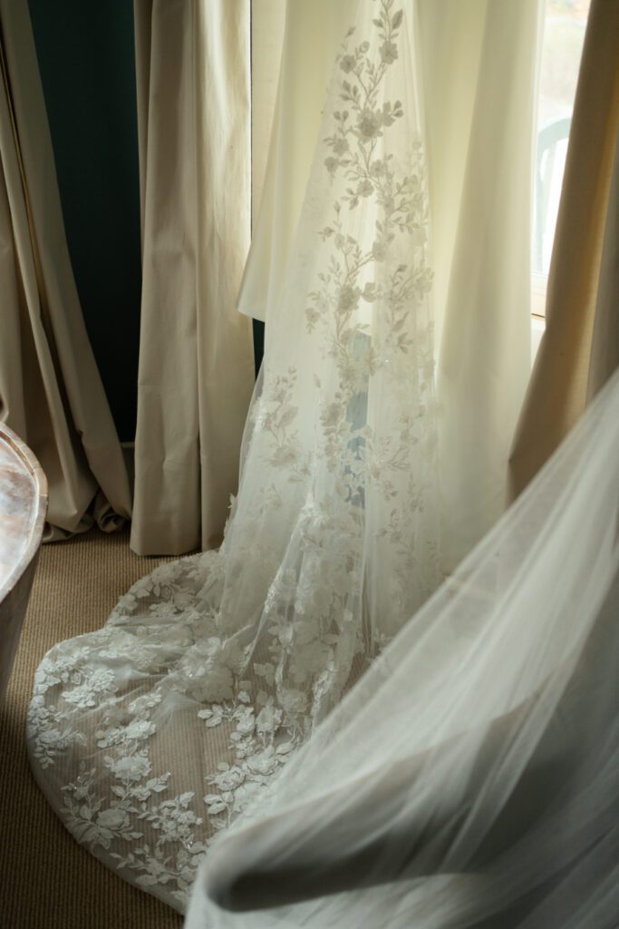 close up of brides wedding gown hanging in the window.