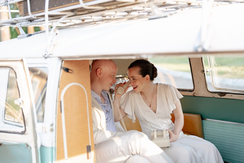 bride and groom inside their NY photo bus rental for their outdoor wedding ceremony at city winery.