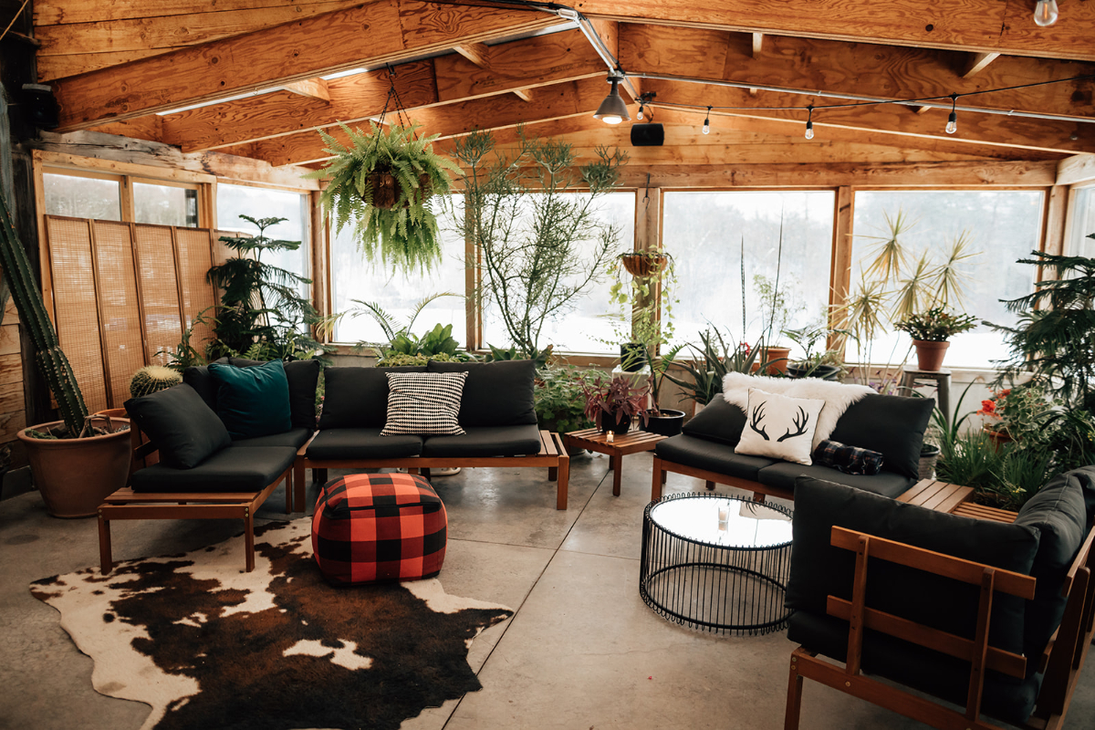 Cozy indoor lounge at The Arnold House with modern seating, layered textiles, and lush greenery, offering a relaxed gathering space for guests attending destination weddings in Hudson Valley.
