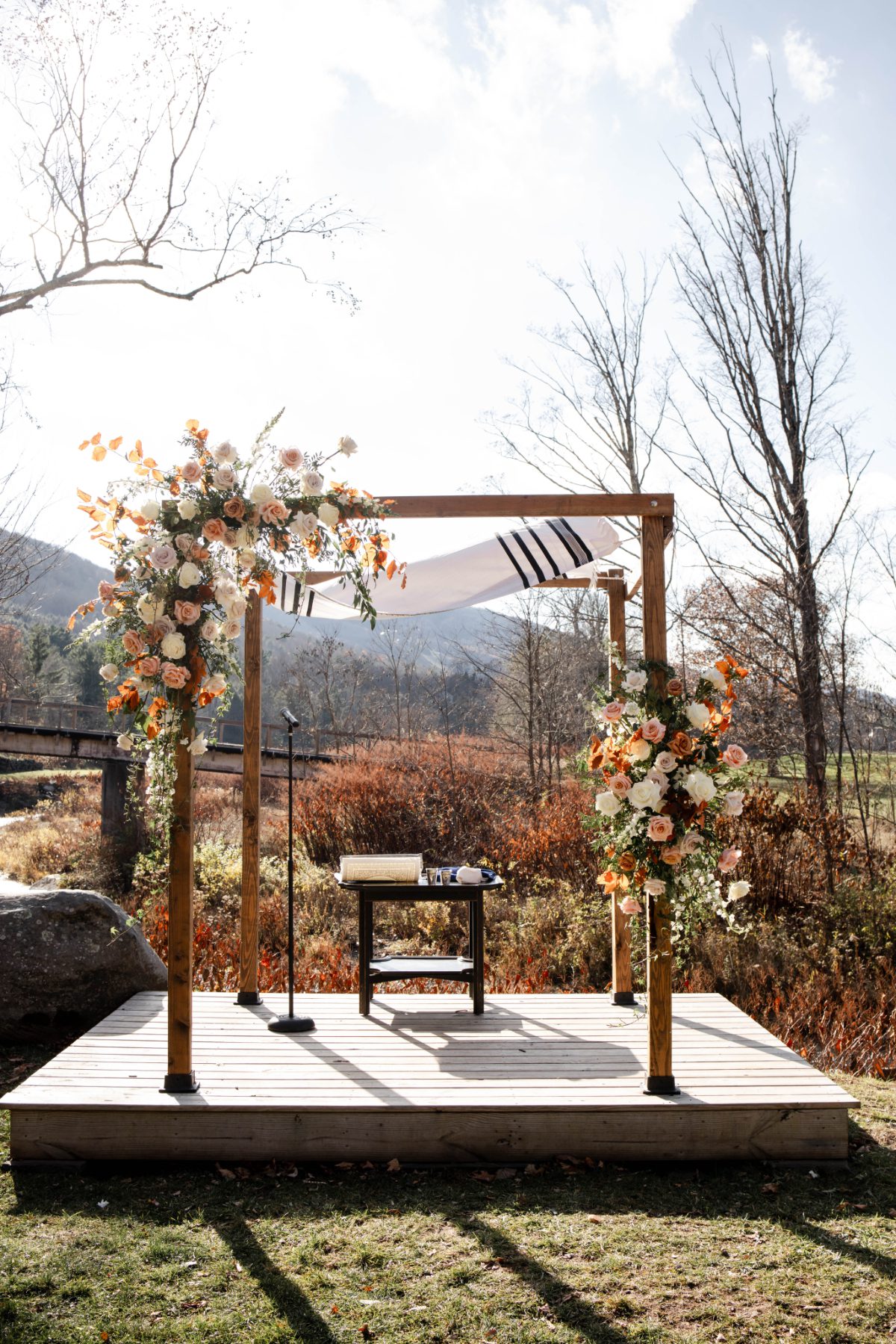 Outdoor ceremony arch with soft florals and draped fabric at Wylder at Windham, set against mountain views and autumn tones—an elegant setting for destination weddings in Hudson Valley.